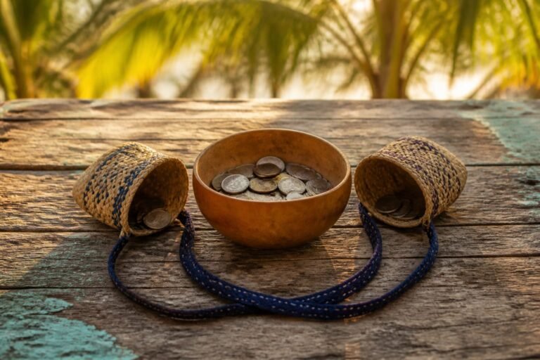 Two woven coin purses tipped towards a shared calabash bowl in warm Caribbean light.