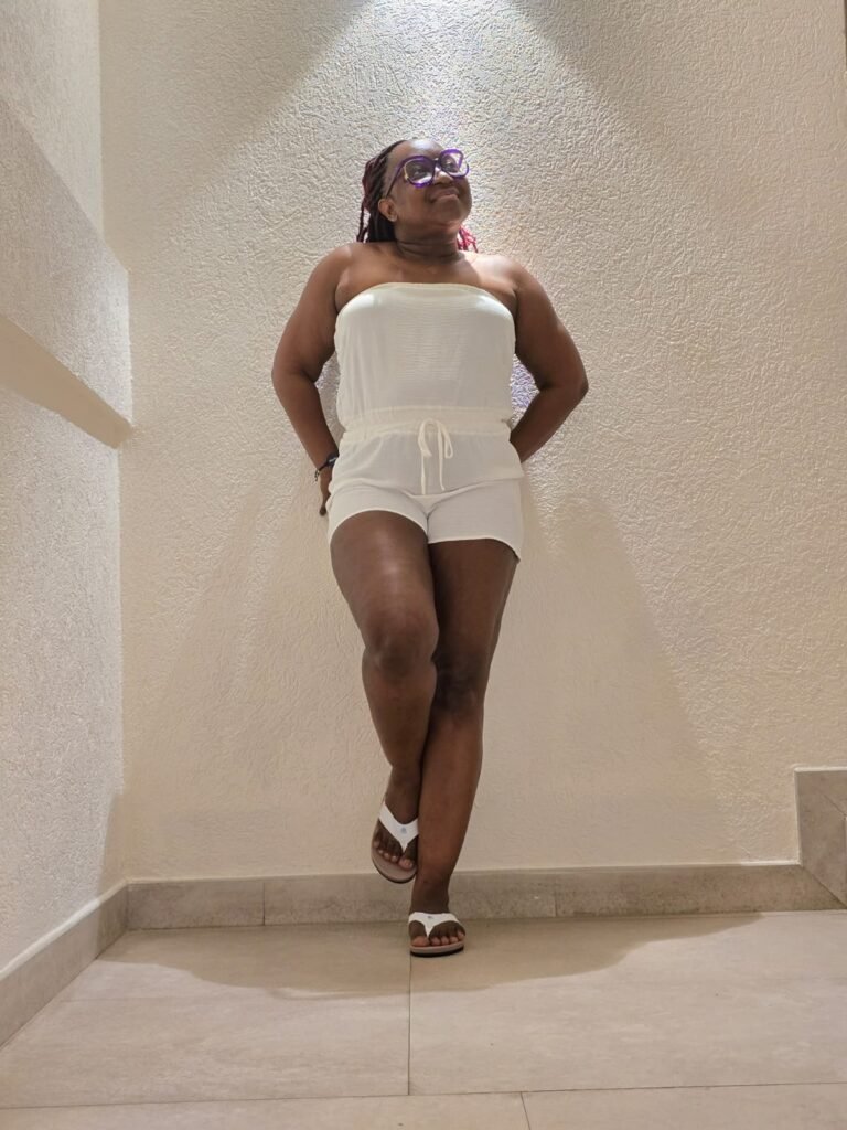 Sharlene Findley-Stewart standing beneath a pool of light, wearing white.